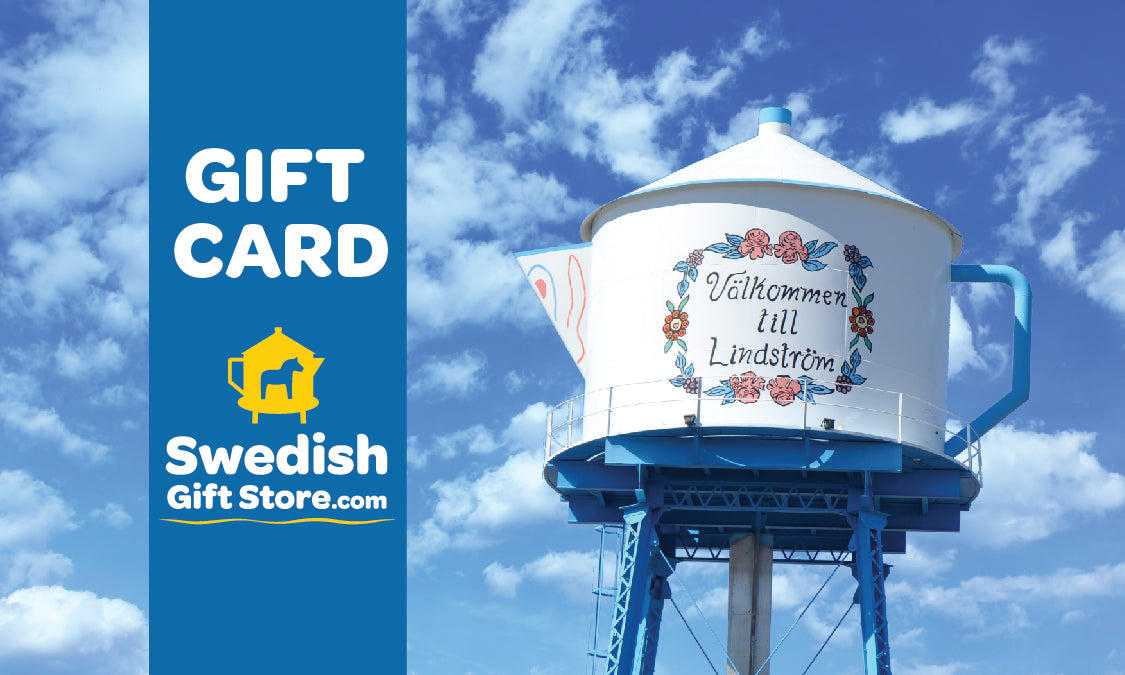 Gift card image featuring a large teapot-shaped water tower with Välkommen till Lindström and a Swedish Gift Store logo on a blue sky background.