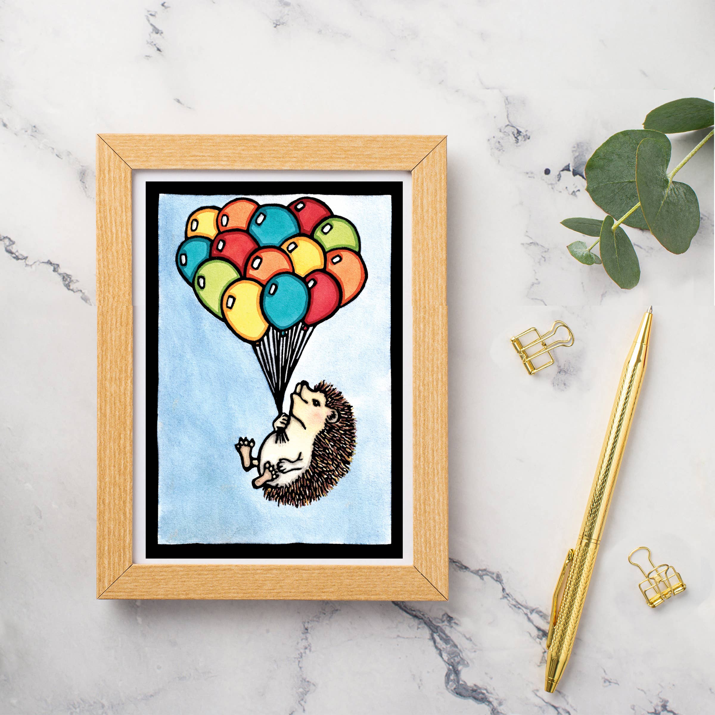 The Card: Up, Up and Away Hedgehog with Balloons is a 5x7 greeting card featuring a charming hedgehog lifted by balloons. Blank inside for your message, it comes with an envelope—perfect for any occasion.