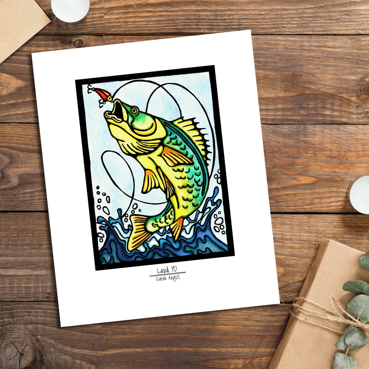 The Land It by Sarah Angst is an 11x14 giclee print with a white mat border, featuring a vibrant fish leaping for a lure—ideal lake life decor to brighten any space.