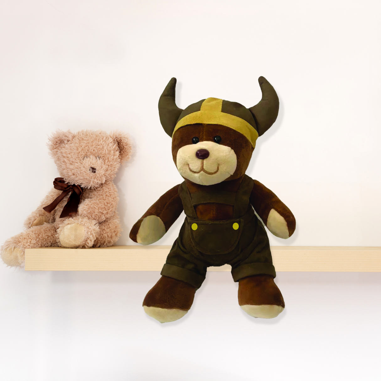 A small Viking Boy Plush Teddy Bear in a horned helmet and overalls sits on a shelf, making an adorable nursery companion or unique Oktoberfest gift.