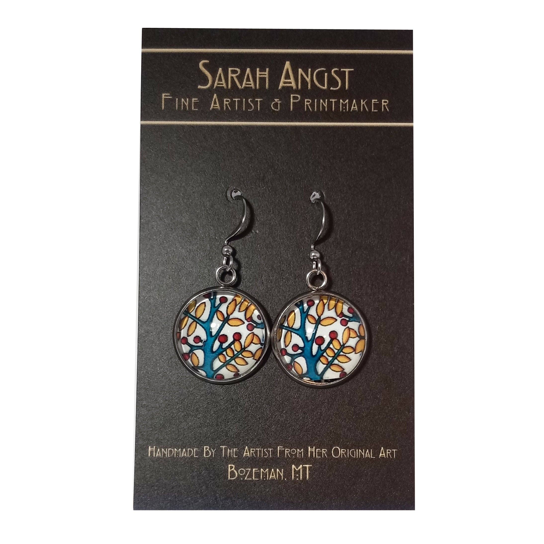 Vibrant handmade round earrings from Sarah Angst Art, showcasing an abstract bird and floral design, elegantly presented on a branded card.