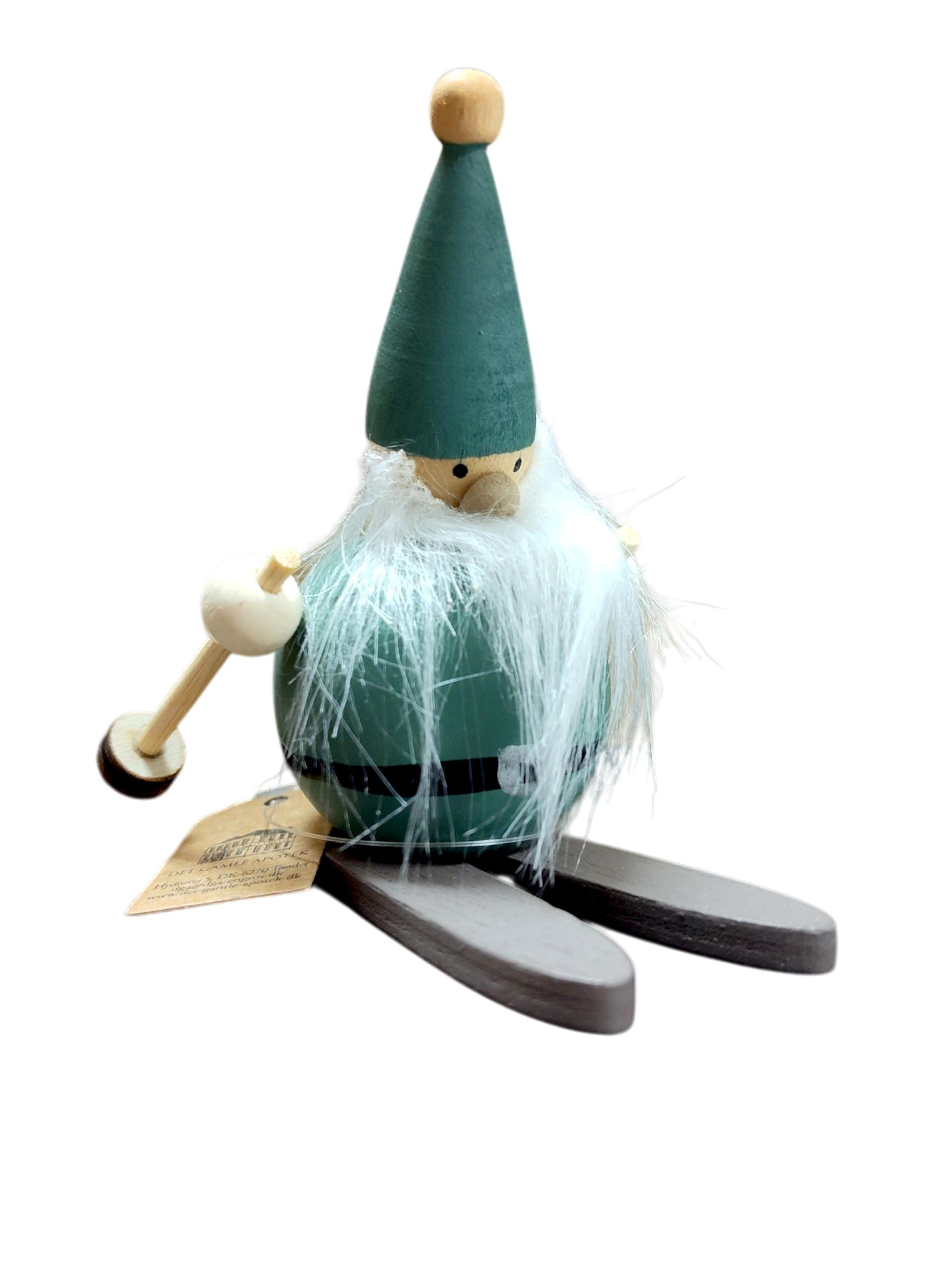 The Figurine: Green Nisse on Skis Handcrafted Swedish Figurine features a wooden Nisse with a green hat, white faux beard, skis, mallet in hand, and tag—an enchanting Scandinavian décor piece.