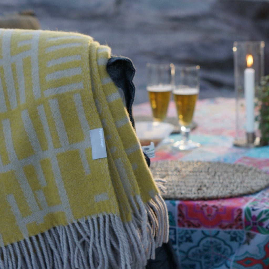 A light olive wool blanket draped over a chair.