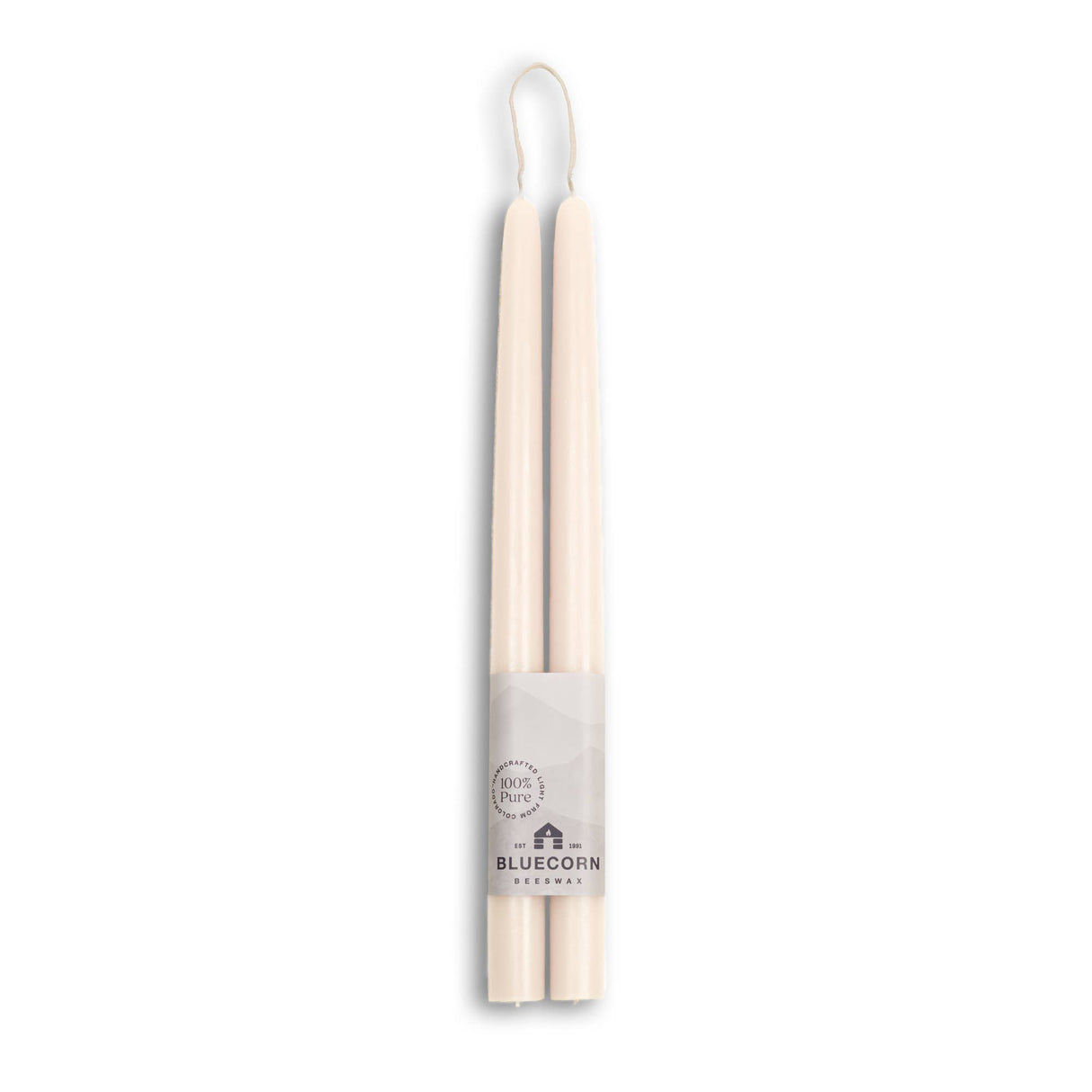 Two 10 eco-friendly, dripless, and handmade white beeswax taper candles are tied together with a Bluecorn Beeswax label featuring a mountain design, stating 100% Pure, ensuring a clean and sustainable burn for any occasion.