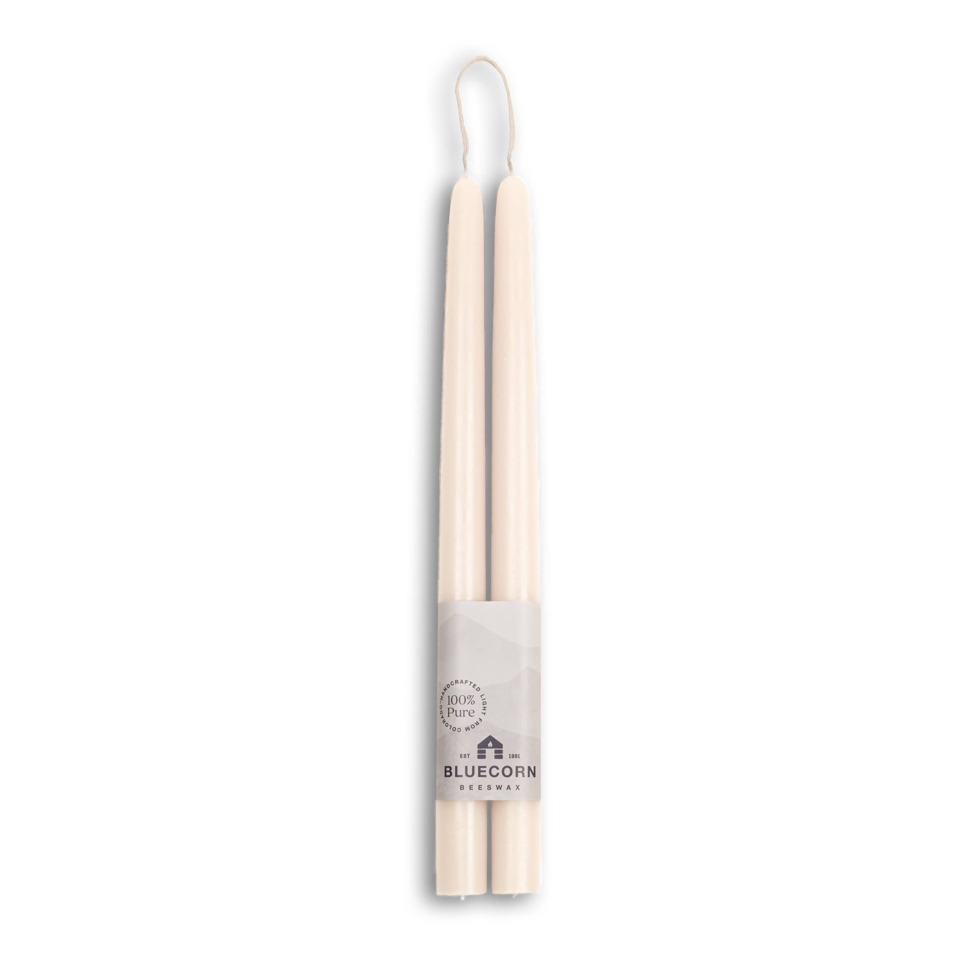 Two 10 eco-friendly, dripless, and handmade white beeswax taper candles are tied together with a Bluecorn Beeswax label featuring a mountain design, stating 100% Pure, ensuring a clean and sustainable burn for any occasion.