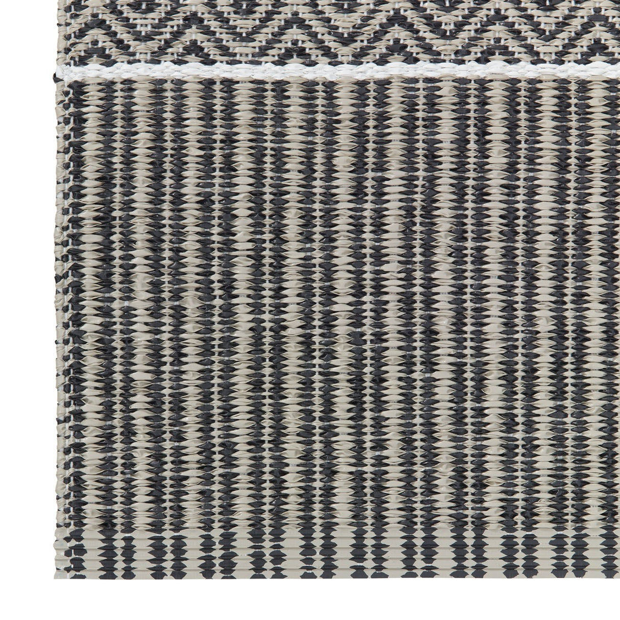 Close-up of the Alfie - Graphite vinyl rug by Horredsmattan showcasing a woven textile pattern with horizontal and vertical black and beige stripes and a geometric design at the top, crafted as an environmentally friendly PVC Swedish product.