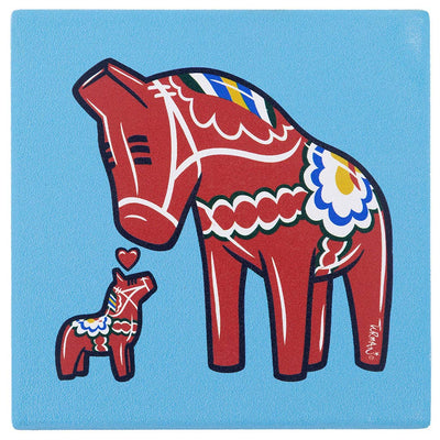 Featuring art by Adam Turman, the 4x4 stone Dala Horses Coaster shows two red Dala horses with decorative patterns and a heart above them on a blue background. This coaster includes cork backing for added durability.