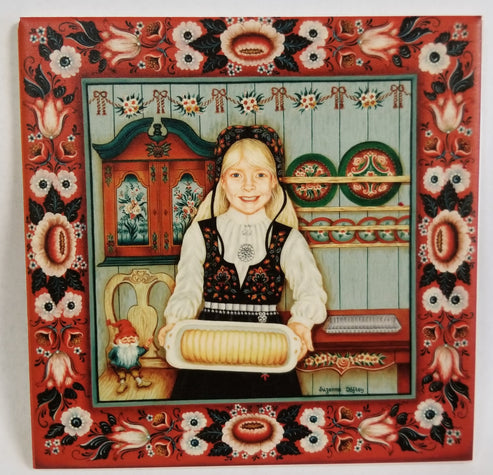 A smiling girl in folk attire holds a pastry in a decorated kitchen with Norwegian rosemaling, featured on the 6" Almond Cake Baker Tile Trivet (with hanger & cork backing), framed by a red floral border.