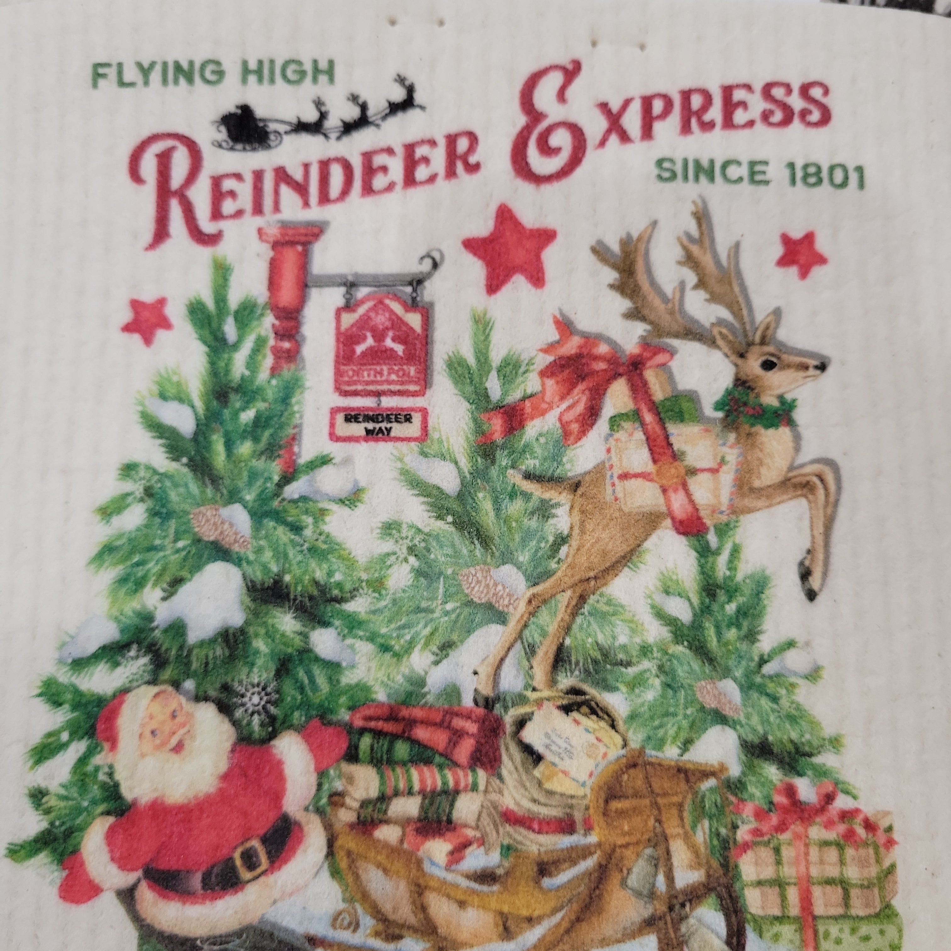 Illustration of Santa, a reindeer with gifts, trees, and a “Reindeer Express” sign with “Flying High” and “Since 1801” text. Santa’s sleigh is filled with presents and the Reindeer Express Swedish Dish Cloth for easy holiday cleaning.