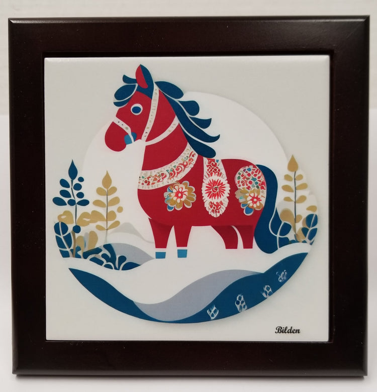 This framed artwork, titled "Swedish Dala Horse Winter Folk Horse," showcases a stylized red horse reminiscent of traditional Swedish craftsmanship, embellished with floral designs and surrounded by decorative flora on a white tile set in a wooden frame.