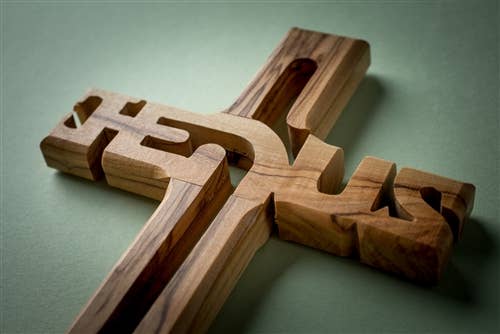 A 4" Olive Wood Cross Ornament from Bethlehem, laser-cut with "Jesus," beautifully crafted as a meaningful Holy Land keepsake.