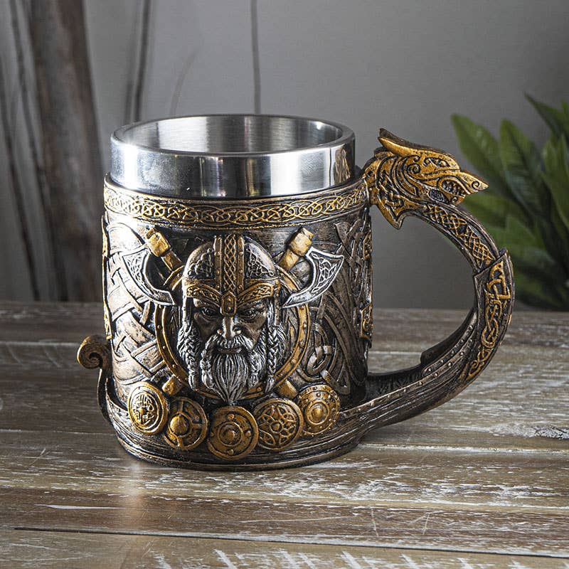 The Mug: Viking Ship Mug with Dragon Head, featuring Thors Hammer, shields, and Viking motifs, sits on a wooden surface.