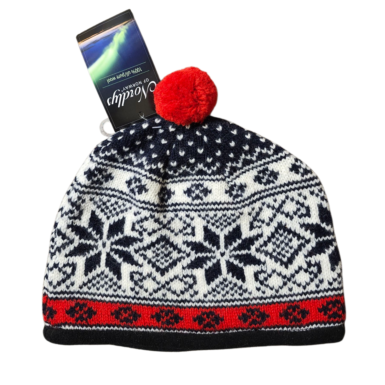 The Nordlys Classic Norwegian Star Knit Hat (Navy/Red) features a red pom-pom and Nordic star patterns in navy, red, and white, with a box of chocolate tucked into the top.