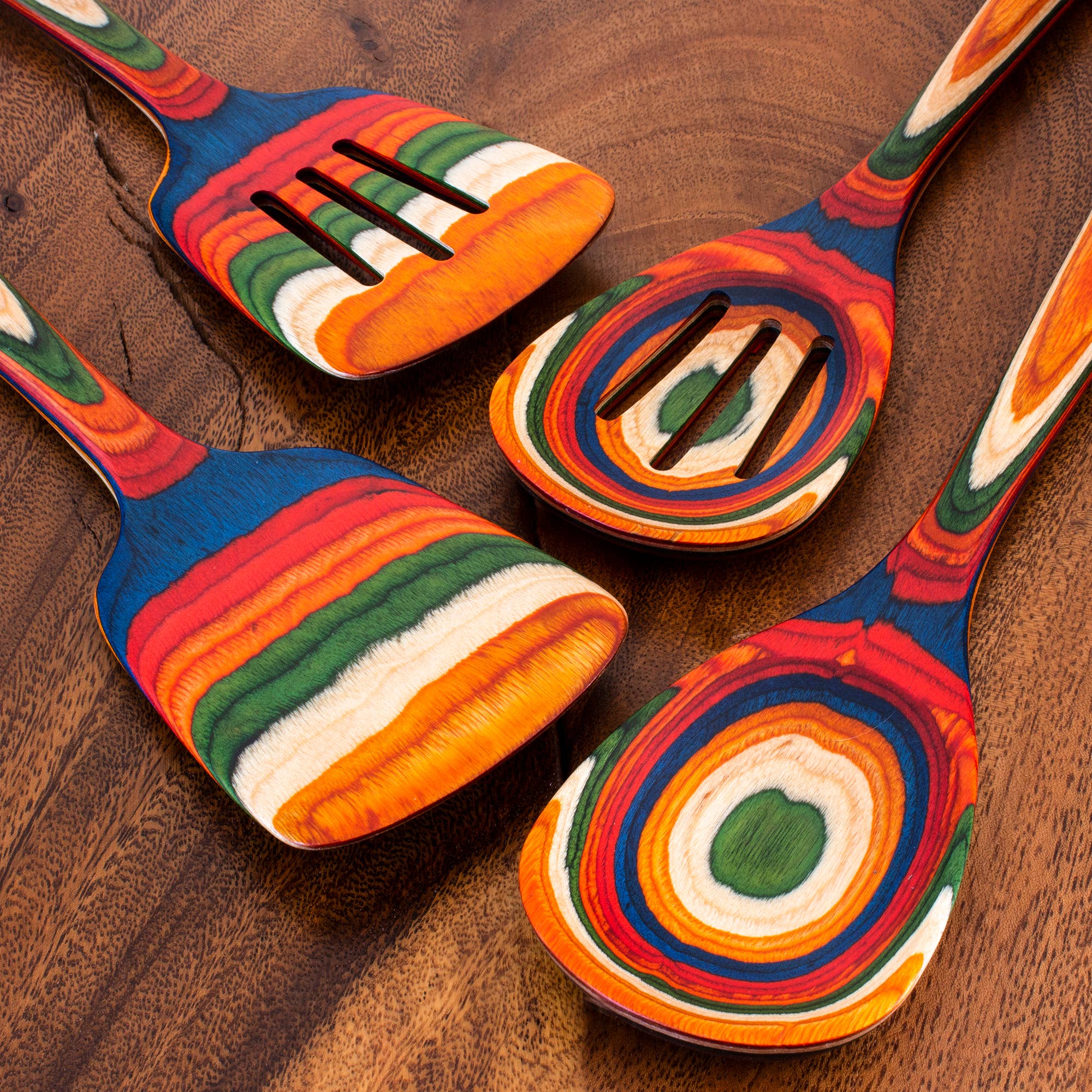 The Marrakesh Mixing Wooden Spoon Birch features vibrant, Marrakesh-inspired stripes and rests on a brown wooden surface as part of a stylish birch kitchen utensil set.