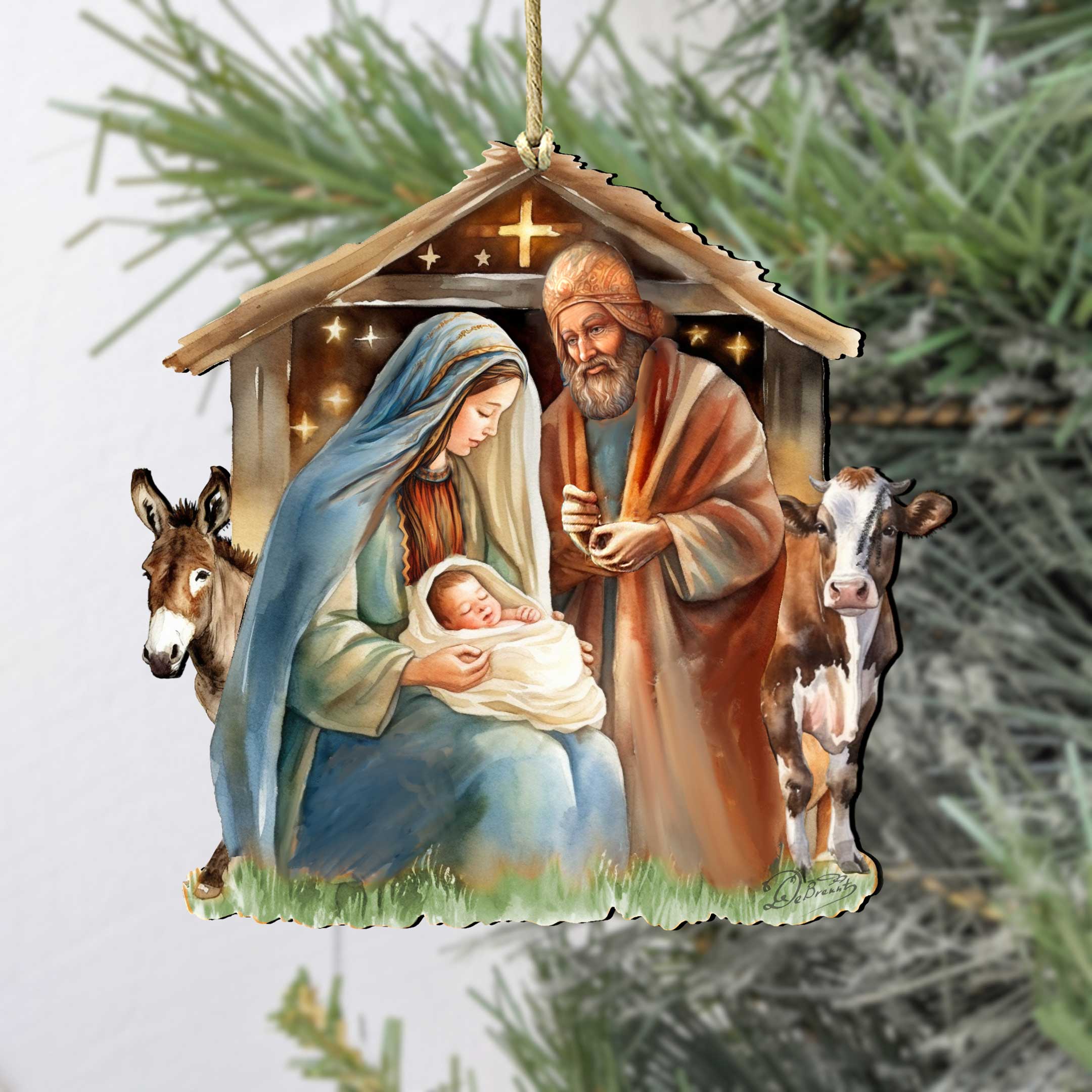 The "Born Under Bright Star Nativity" wooden ornament by G. DeBrekht (approx. 5 x 4.75 in) features Mary, Joseph, baby Jesus, a donkey, and a cow in a stable, beautifully crafted to hang on your tree.