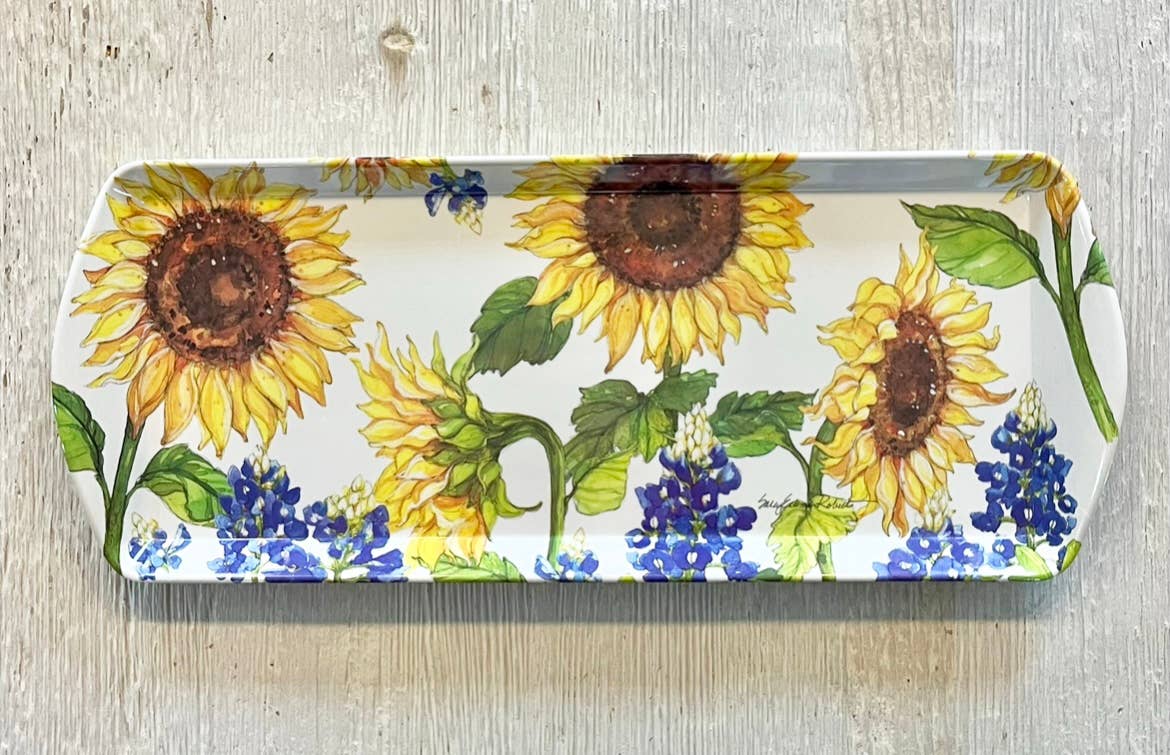 The Tray: Sunflower & Bluebonnets Floral Loaf Serving Charcuterie Tray features a vibrant sunflower and bluebonnet design on bamboo—an eco-friendly choice for serving at your next gathering.