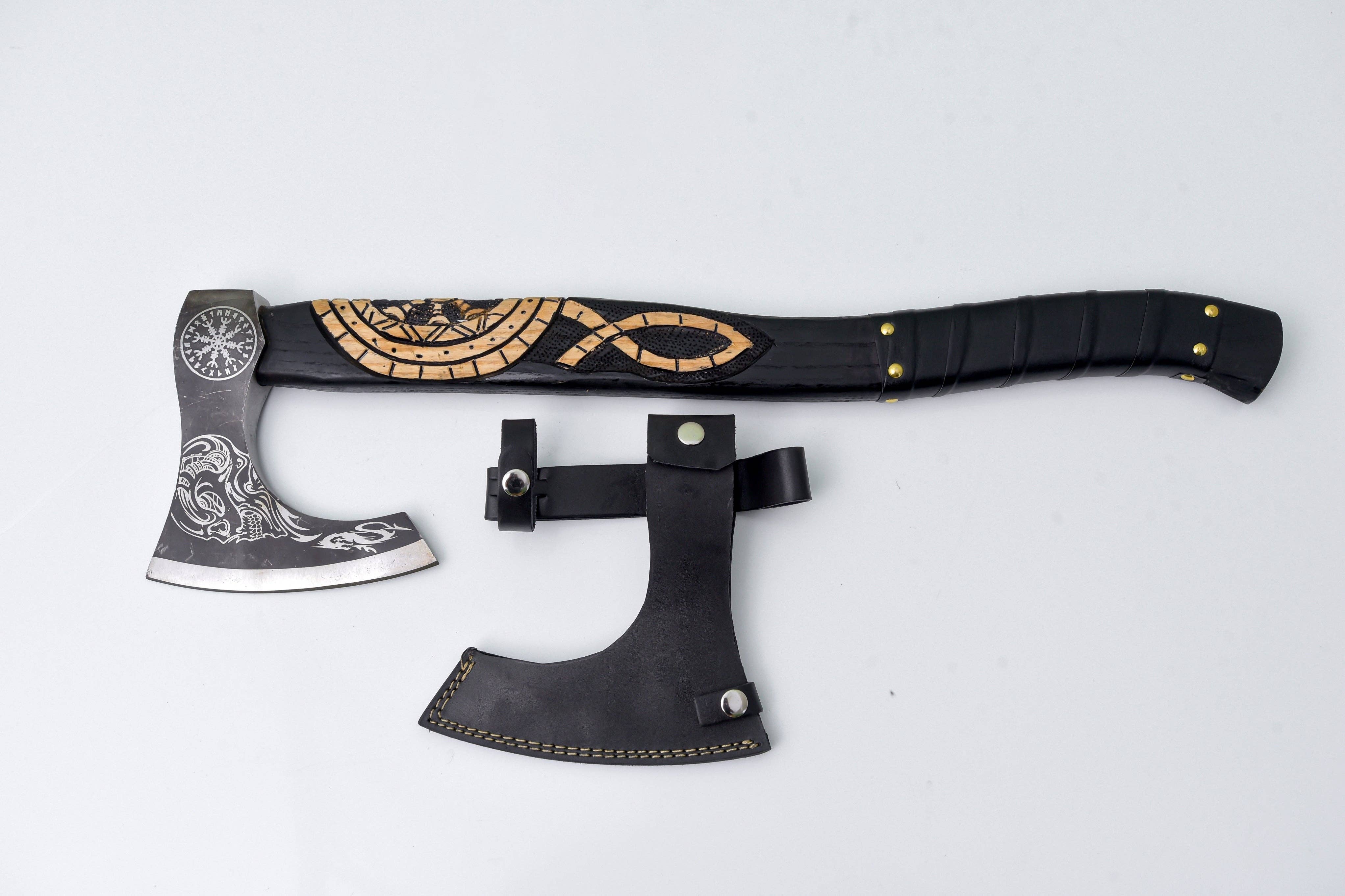 The Axe: Jörmungandr’s Grasp Camping Tool is a Viking-style hatchet with Norse engravings and a patterned handle, displayed with a black leather sheath on a light background.