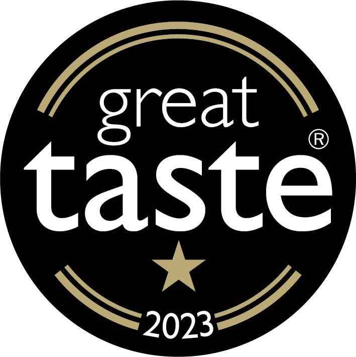 A black circular logo features great taste with a registered trademark in white. Below, a gold star alongside 2023 hints at flavors like the MilkBoy Swiss Alpine White Chocolate with Bourbon Vanilla that elevate your experience.
