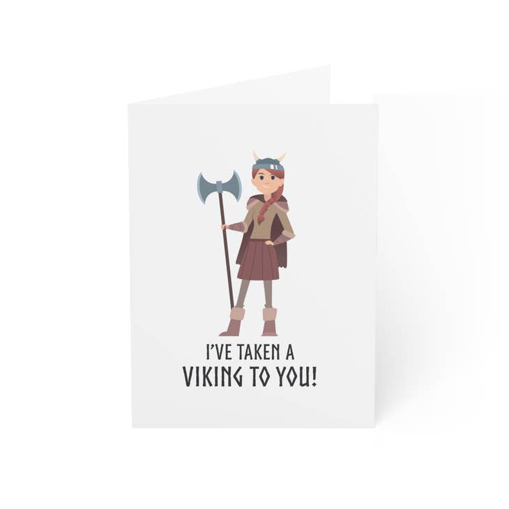 The "I’ve Taken a Viking to You (Female Viking)" Greeting Card (blank inside) features a cartoon character—great as a playful Valentine’s Day or Nordic romance card.