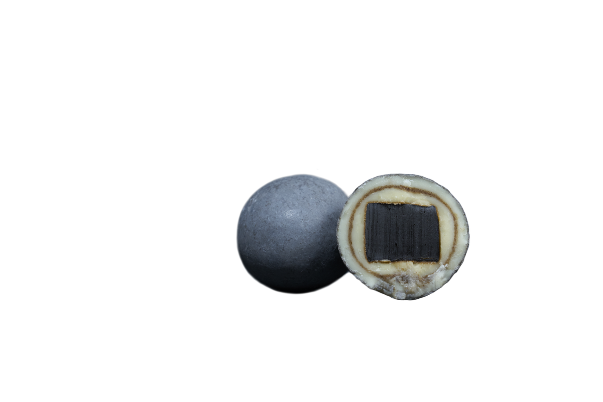 Two round Nordic licorice candies on a white background; one is whole, the other is halved to show a black center, white middle layer, and gray outer coating.