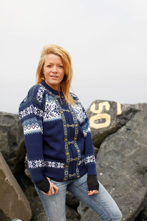 Navy blue wool cardigan with white Nordic snowflake patterns and decorative metal clasps.