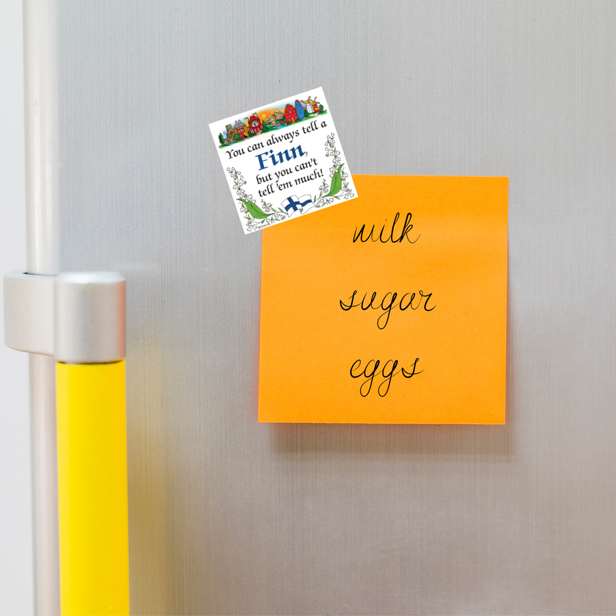 An orange sticky note on a fridge lists milk, sugar, eggs. Above it, a Scandinavian fridge magnet features a quote and floral border with Finnish design elements.