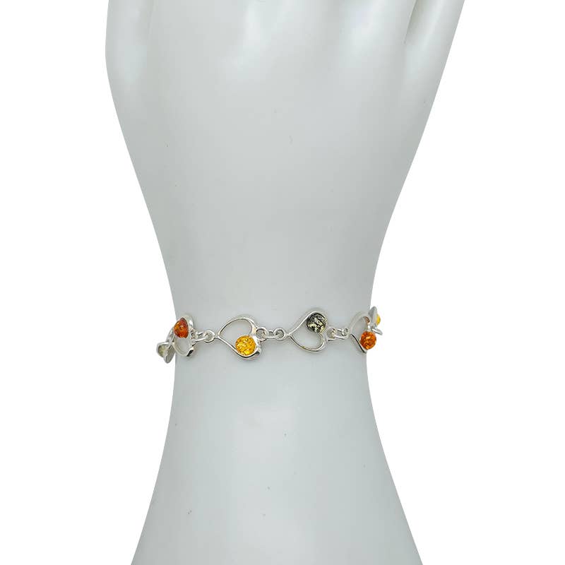 The Bracelet: Multi-Color Baltic Amber Sterling Silver Heart Bracelet, 8" long, featuring vibrant amber stones, is elegantly displayed on a mannequin hand.