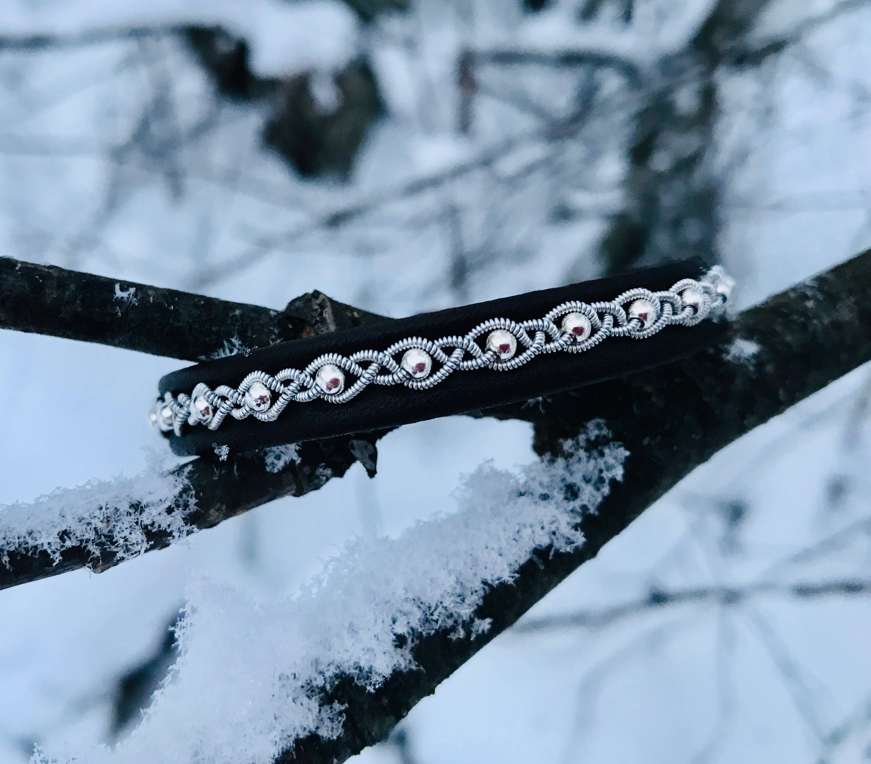 The Bracelet: Sami Lapland Bracelet With Reindeer Hide Pewter & Silver Beads #27: Black rests on a snow-covered tree branch.
