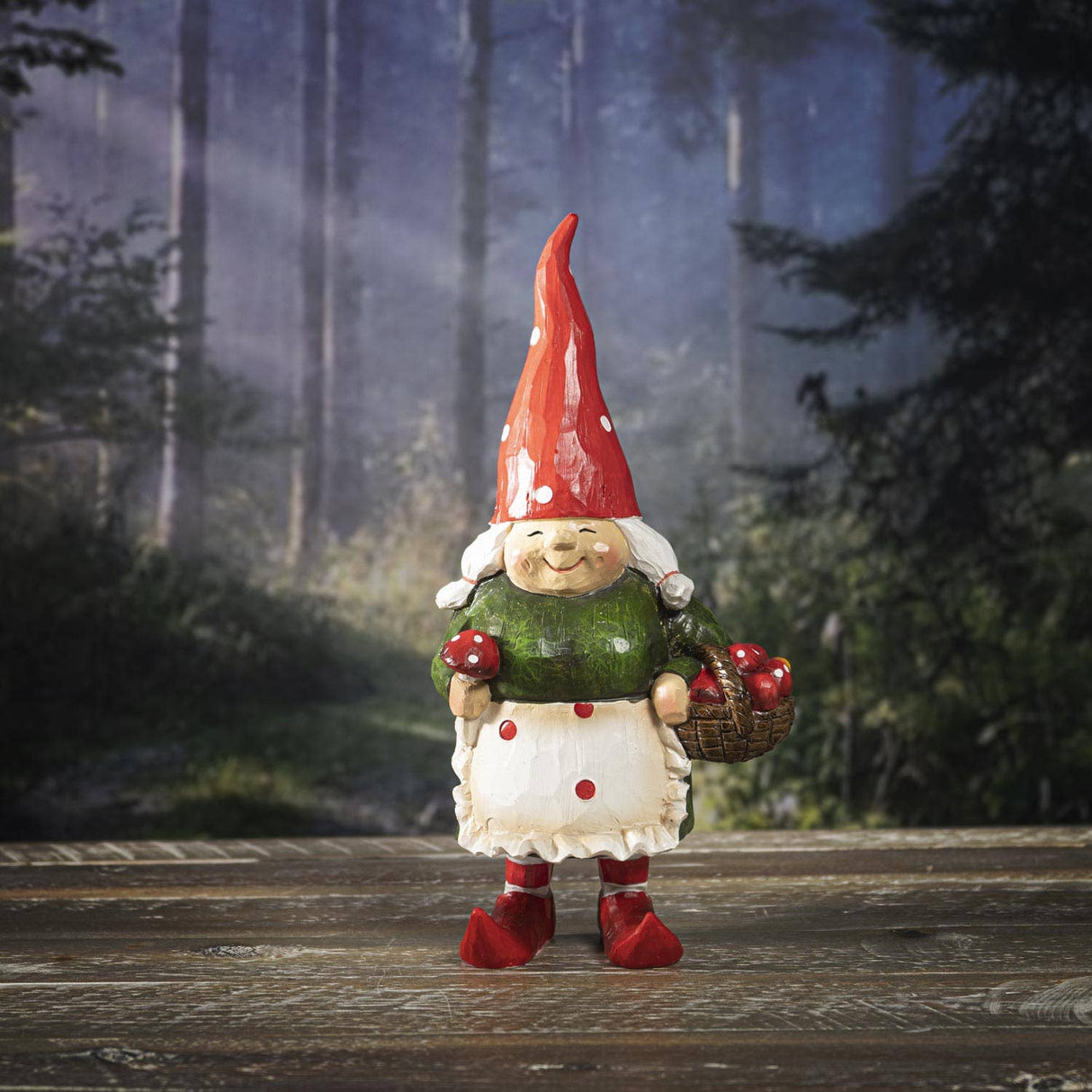 The Gnome: Granny Gnome - 9.72" is a hand-painted resin figurine featuring a granny gnome with a red hat, green top, and basket of red apples—perfect for woodland décor on any wooden surface.