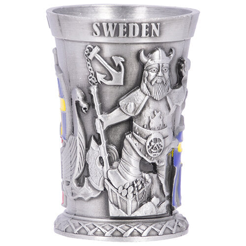 A metal shot glass featuring Viking reliefs, including an anchor and shield design, intricately engraved with "Sweden" at the top. This item elegantly encapsulates the spirit of Swedish culture.