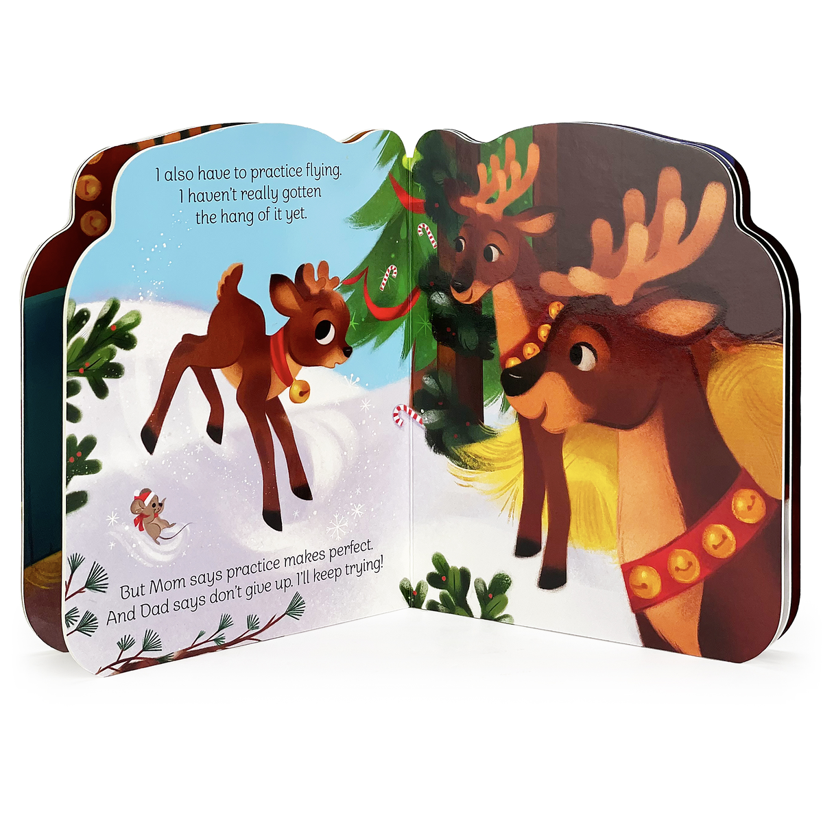 Open Christmas reindeer board book featuring an illustration of a small reindeer flying in the snow with two adult reindeer standing beneath a Christmas tree.