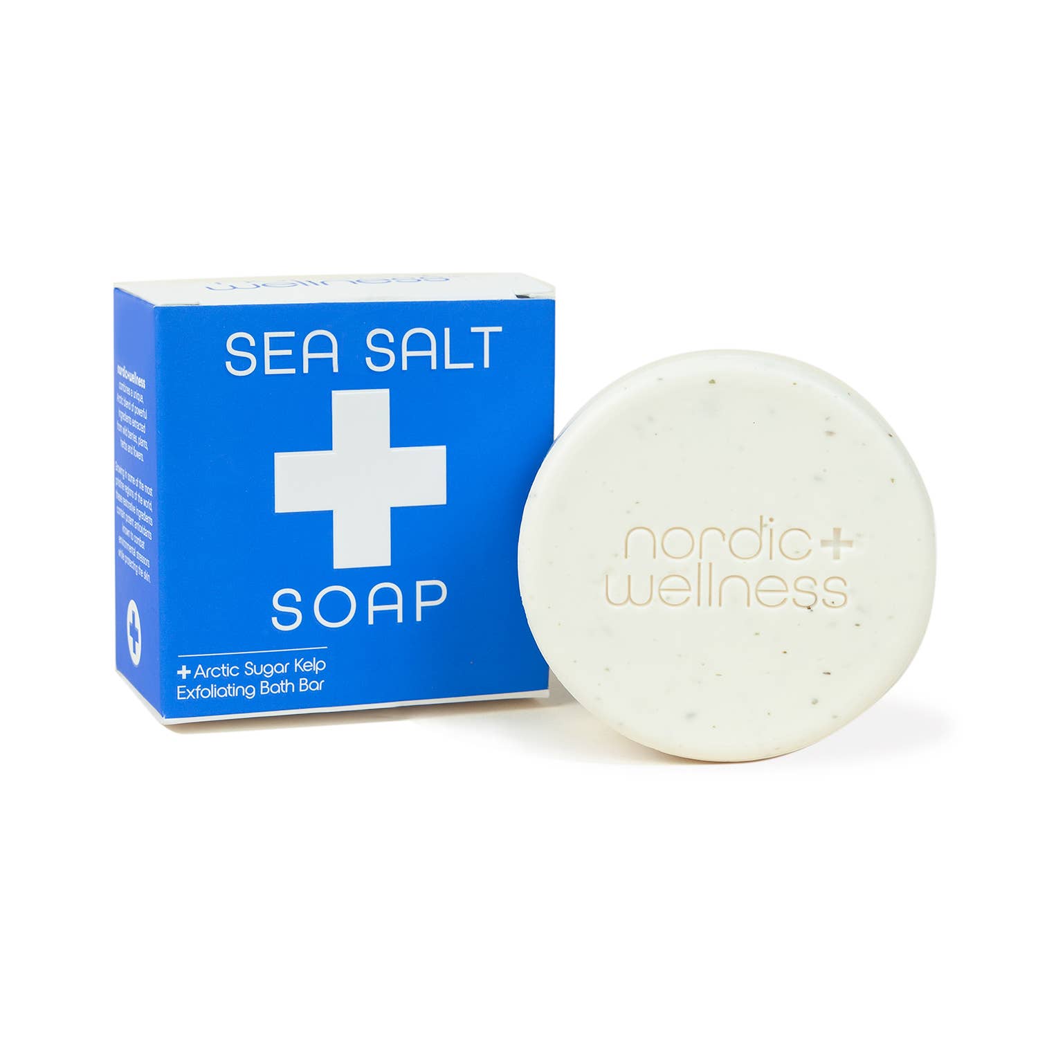 A round bar of Nordic+Wellness™ Sea Salt Soap with Arctic Sugar Kelp, inspired by the Norwegian Sea, sits beside a blue box labeled SEA SALT SOAP featuring a white cross and product details.