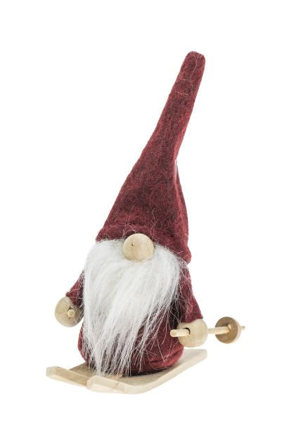 This delightful figurine, the "Little Skiing Santa," features a gnome wearing a long red hat made of wool felt and a flowing white beard, perfectly capturing the whimsy of winter adventures.