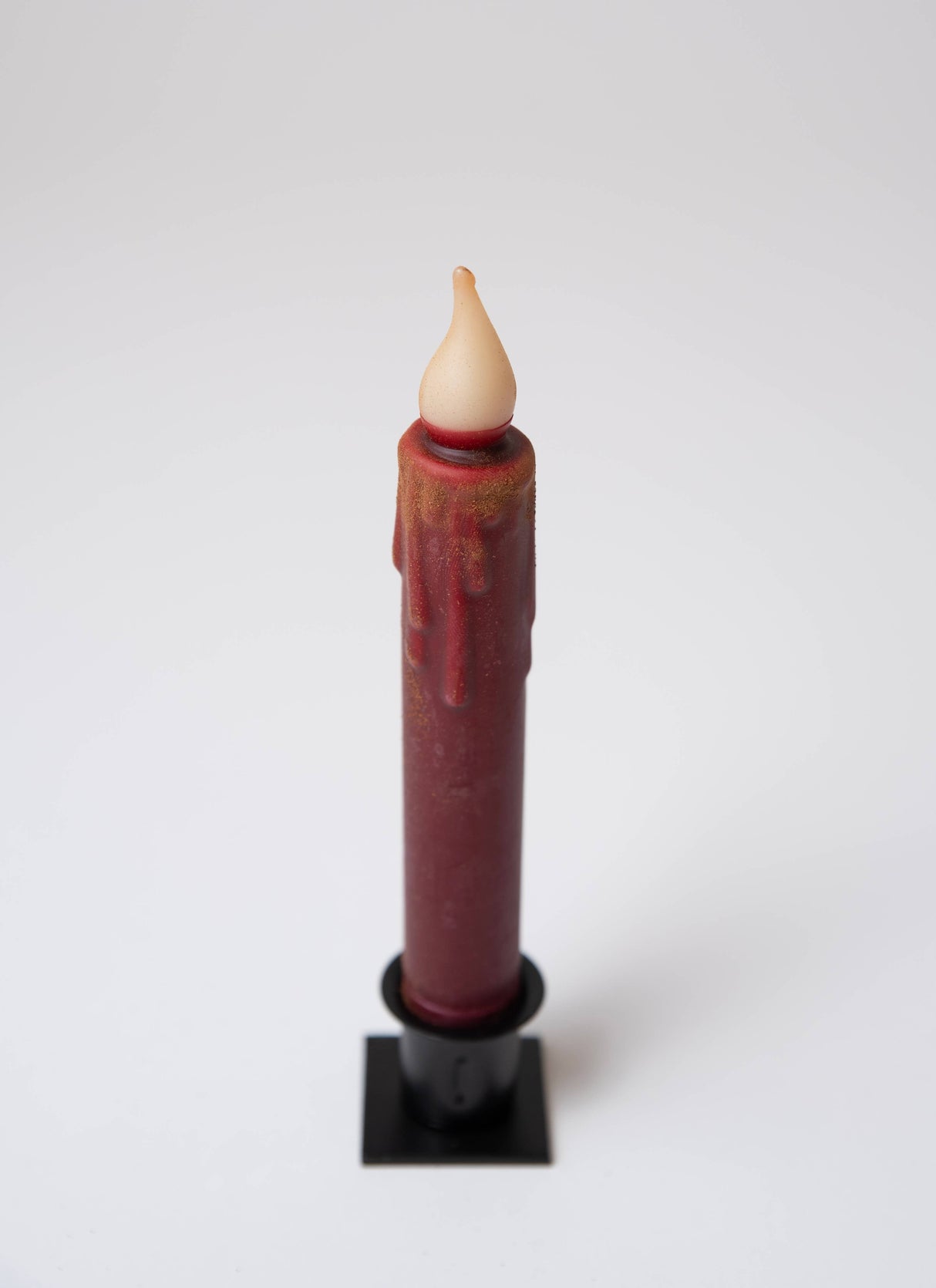 The Candle: Burgundy Cinnamon Dusted LED Timer Taper Candle, 7", features a faux flame tip and stands upright in a black holder—ideal for adding farmhouse charm to your home décor.