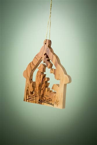 The 3" Stable with Nativity and Animals Christmas Tree Ornament features a nativity scene carved from olive wood, "Bethlehem" engraved at the base, and hangs from a string against a green background.
