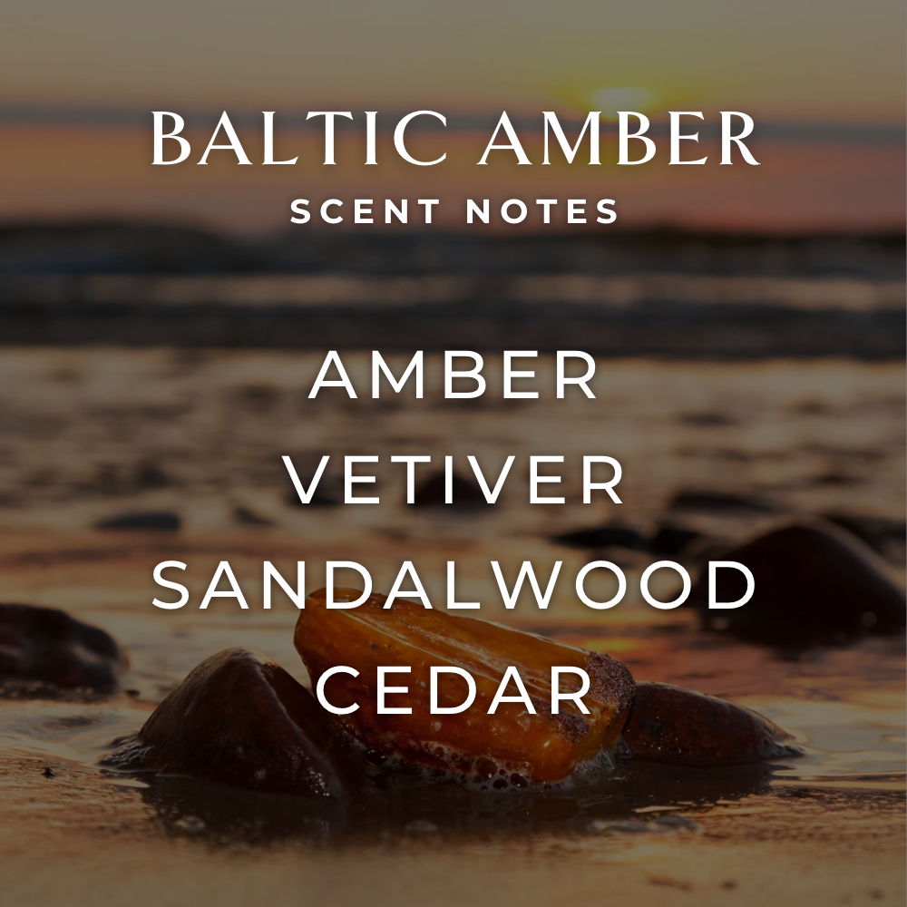 Brown amber stones on a sandy beach at sunset. The Baltic Amber Candle (4oz) blends notes of amber, vetiver, sandalwood, and cedar—crafted with essential oils for an inviting soy wax candle experience.