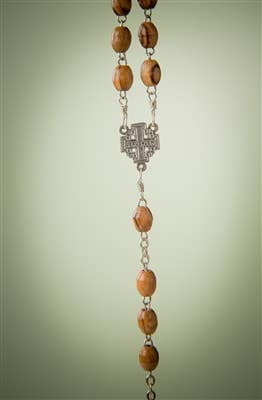 A close-up of the 30 Olive Wood Rosary with Crucifix, handcrafted in Bethlehem with wooden beads and metal centerpiece, shown on a plain light green background.