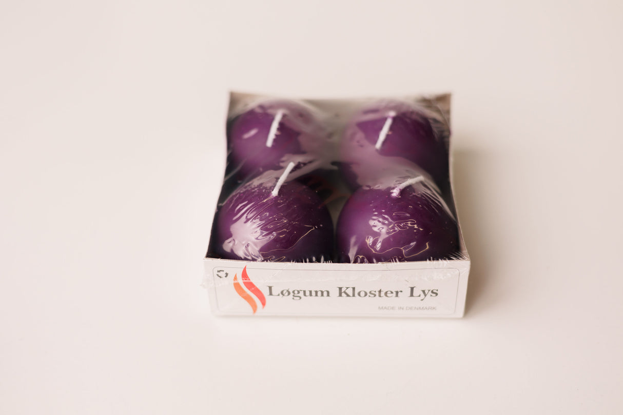 Four purple candles in a white box labeled “Løgum Kloster Lys,” wrapped in clear plastic, set on a white background.