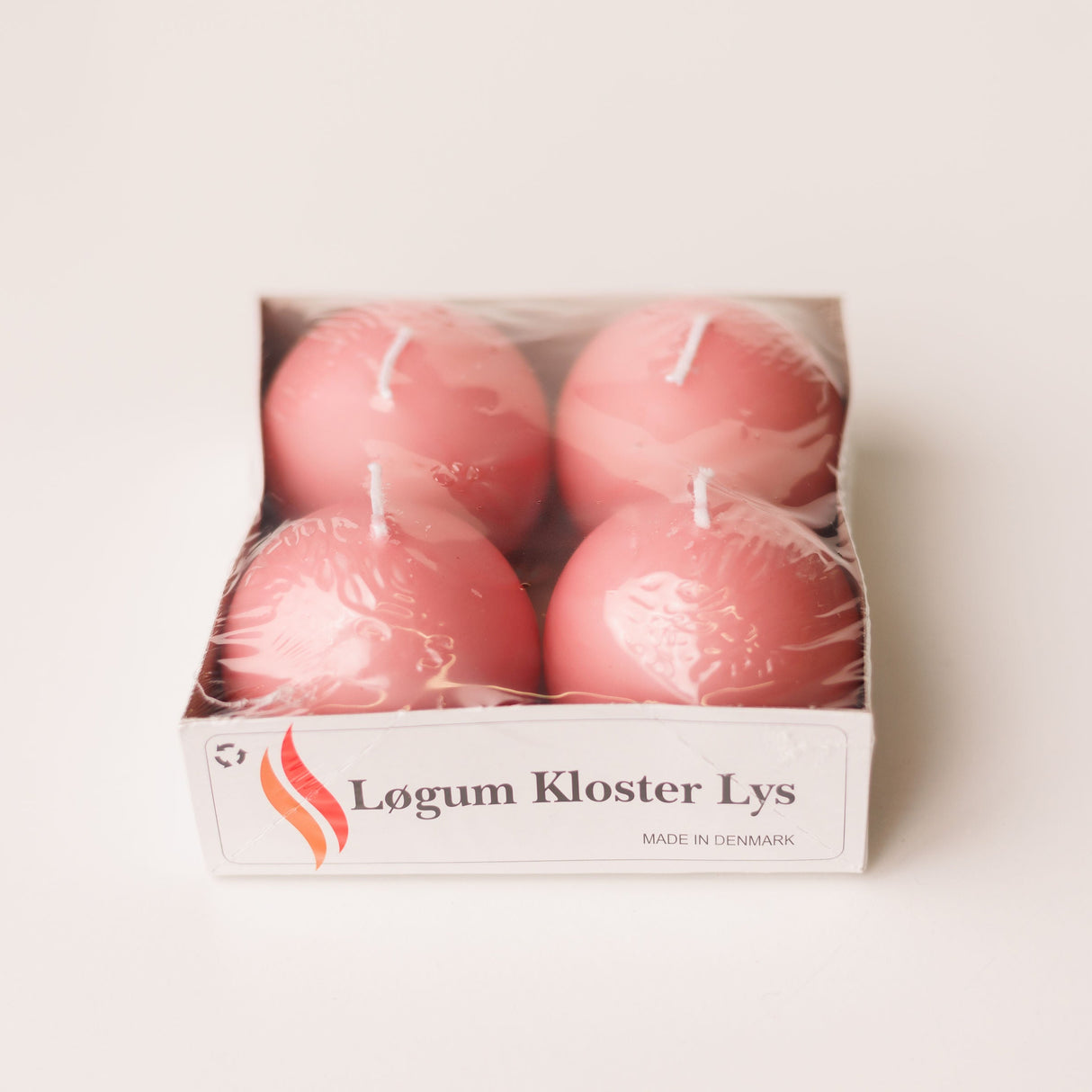 The Logum Kloster Lys 2.5 Ball Candles (4 Pack) features four round pink candles, made in Denmark, wrapped in plastic and labeled for a touch of HYGGE—perfect for cozy decor. Shown against a white background.