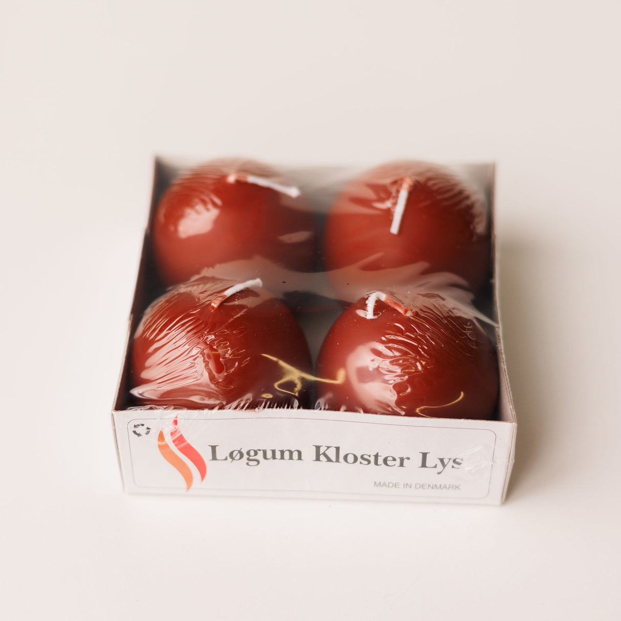 A 4-pack of Logum Kloster Lys 2.5 red ball candles from Denmark, wrapped in plastic, displayed on a white background.