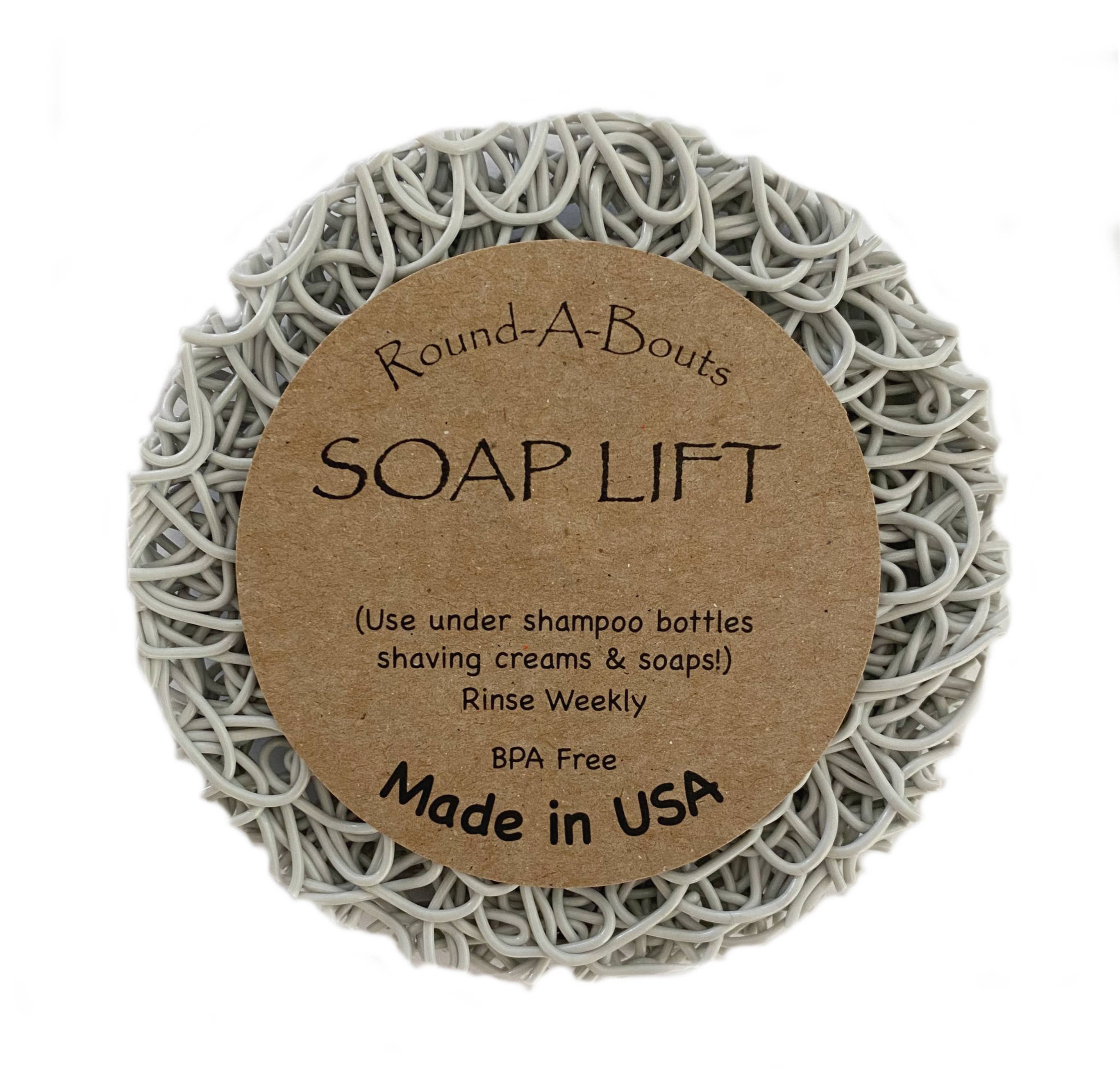 Explore the Soap Lift: Soap Saver Round A Bout - Mist, Light Gray, featuring a circular shape with a curly pattern, made from multi-directional bioplastic. This BPA-free product is crafted in the USA and is perfect for placing under soap bars, shampoo bottles, or shaving creams to help organize your shower shelves with ease.