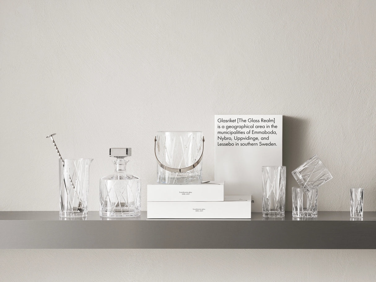 A shelf displays elegant crystal glassware, including a decanter, ice bucket, and a 4-pack of Orrefors City Highball Glasses 12oz, with a sign highlighting Glasriket, the famous Swedish region.