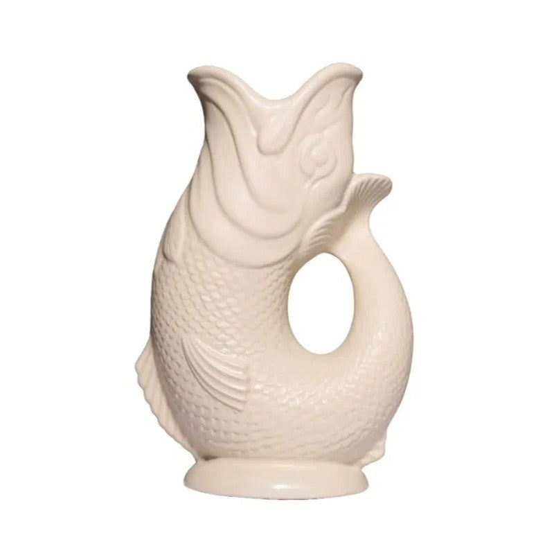 The Classic Gluggle Jug is a cream-colored, fish-shaped pitcher with a curved body handle—an iconic British kitchen decor piece.