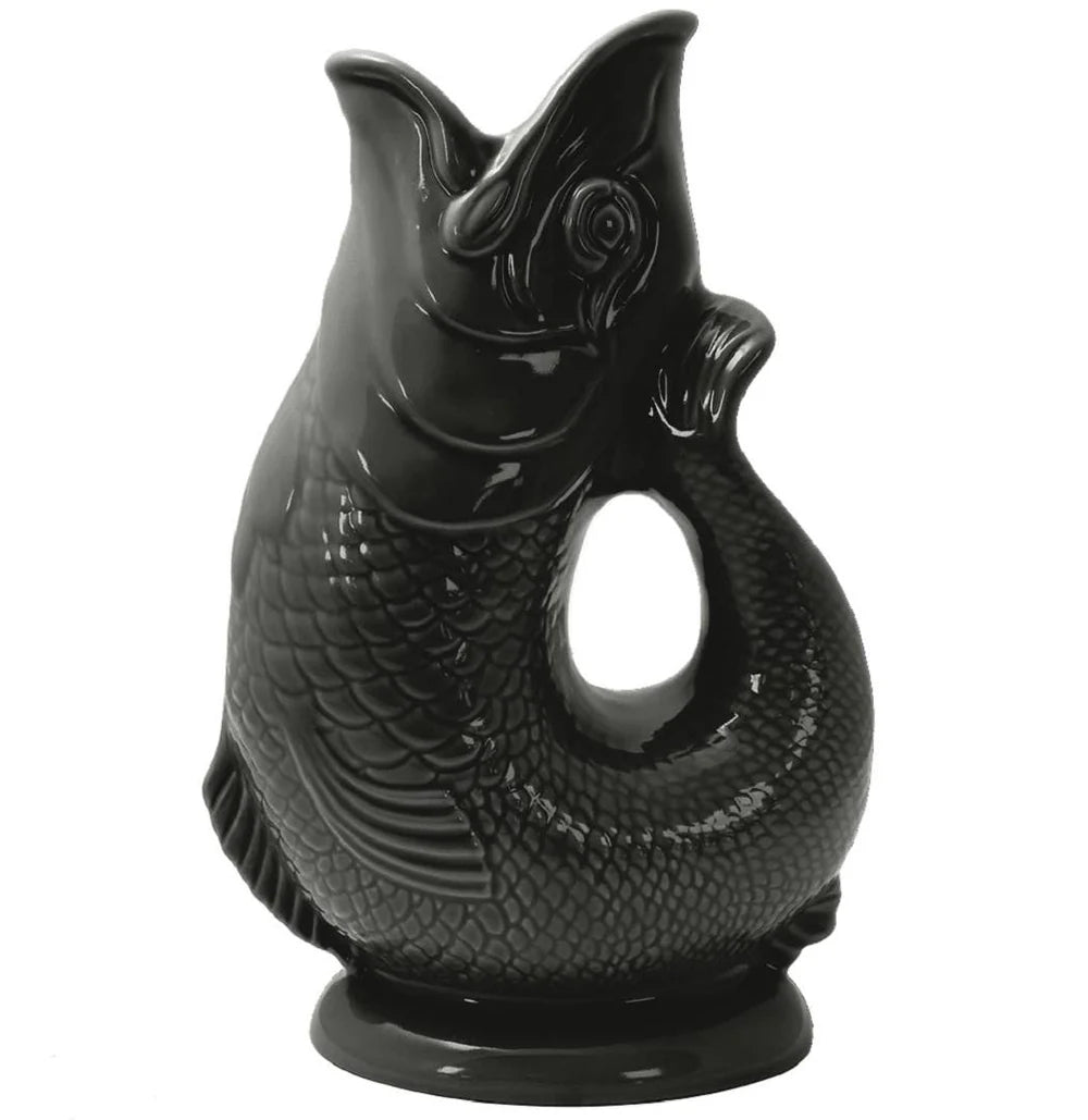 The Classic Gluggle Jug, a glossy black, fish-shaped ceramic piece with an open mouth and curved handle, brings quirky British charm to any kitchen décor.