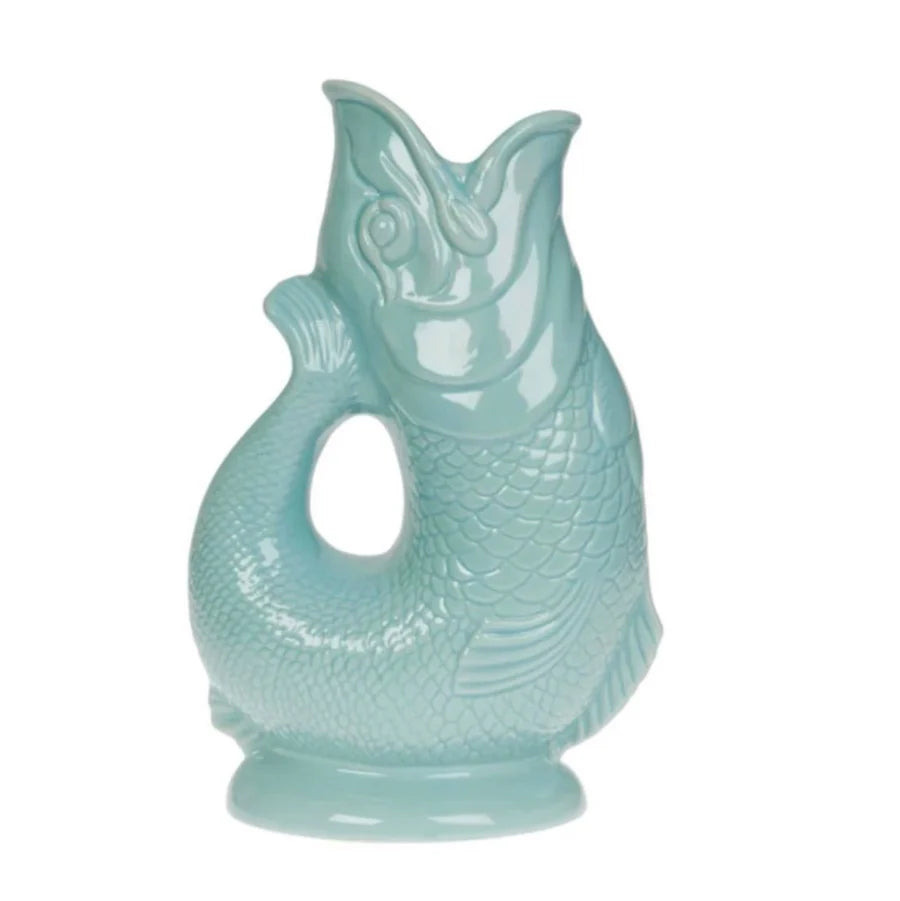 Add quirky British charm to your home with the Classic Gluggle Jug: a glossy light blue, fish-shaped pitcher featuring an open mouth spout and curved tail handle.