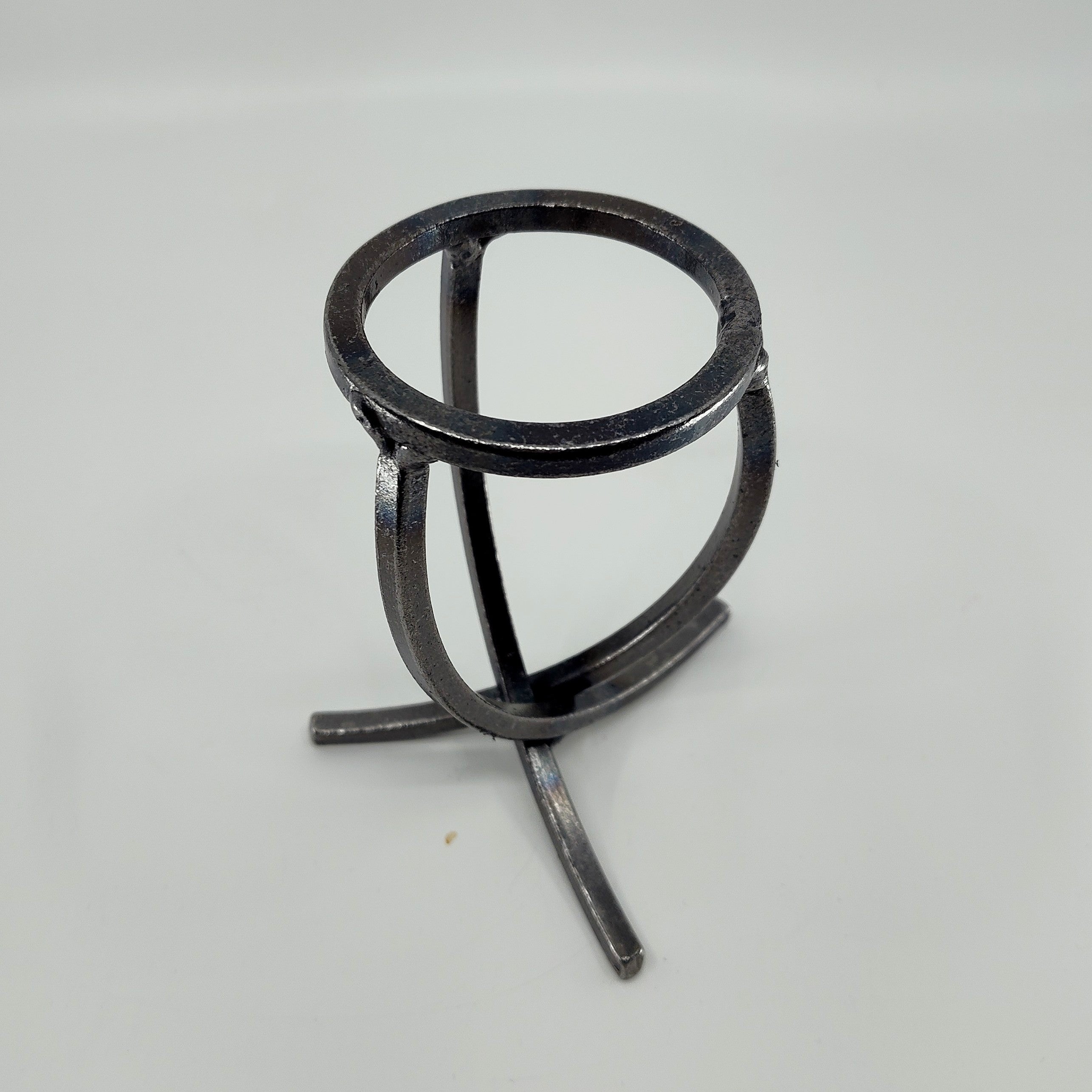 A Danish Iron Candle Holder features a crossed iron base and a Leif cup atop a plain background, designed to hold a ball candle.