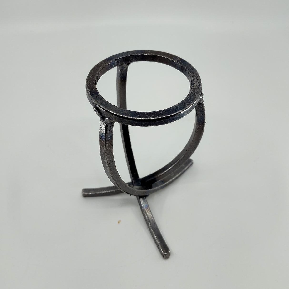 A Danish Iron Candle Holder features a crossed iron base and a Leif cup atop a plain background, designed to hold a ball candle.