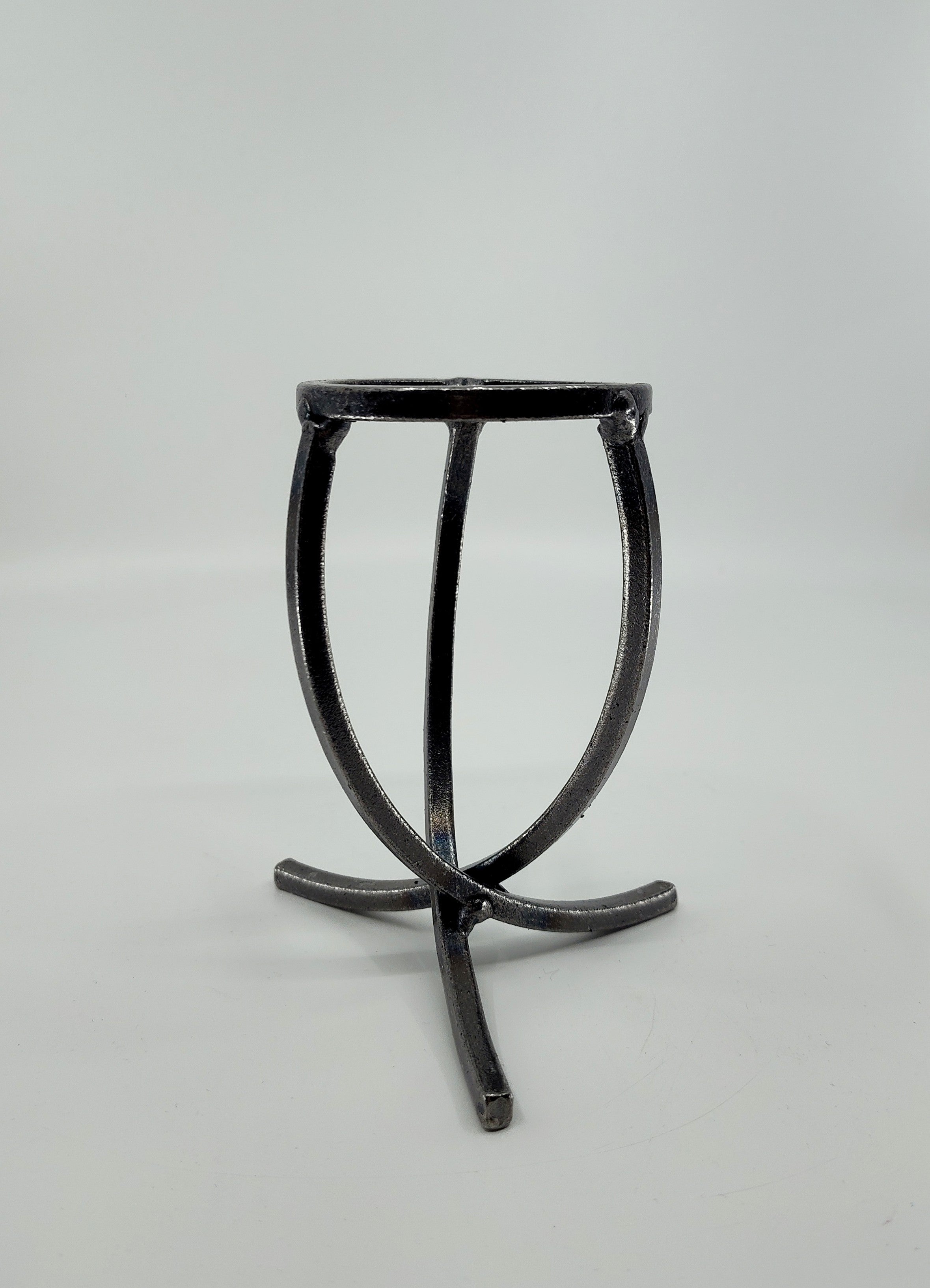 A Danish Iron candle holder with three crossed legs and a circular top in Leif Cup style, showcased on a plain white background.