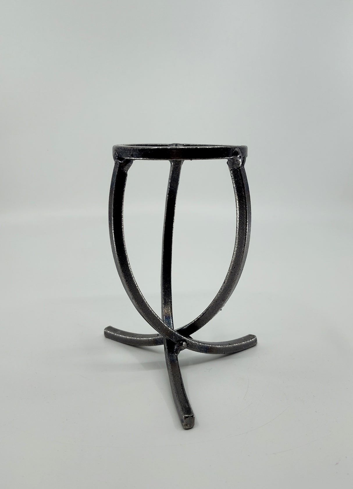 A Danish Iron candle holder with three crossed legs and a circular top in Leif Cup style, showcased on a plain white background.