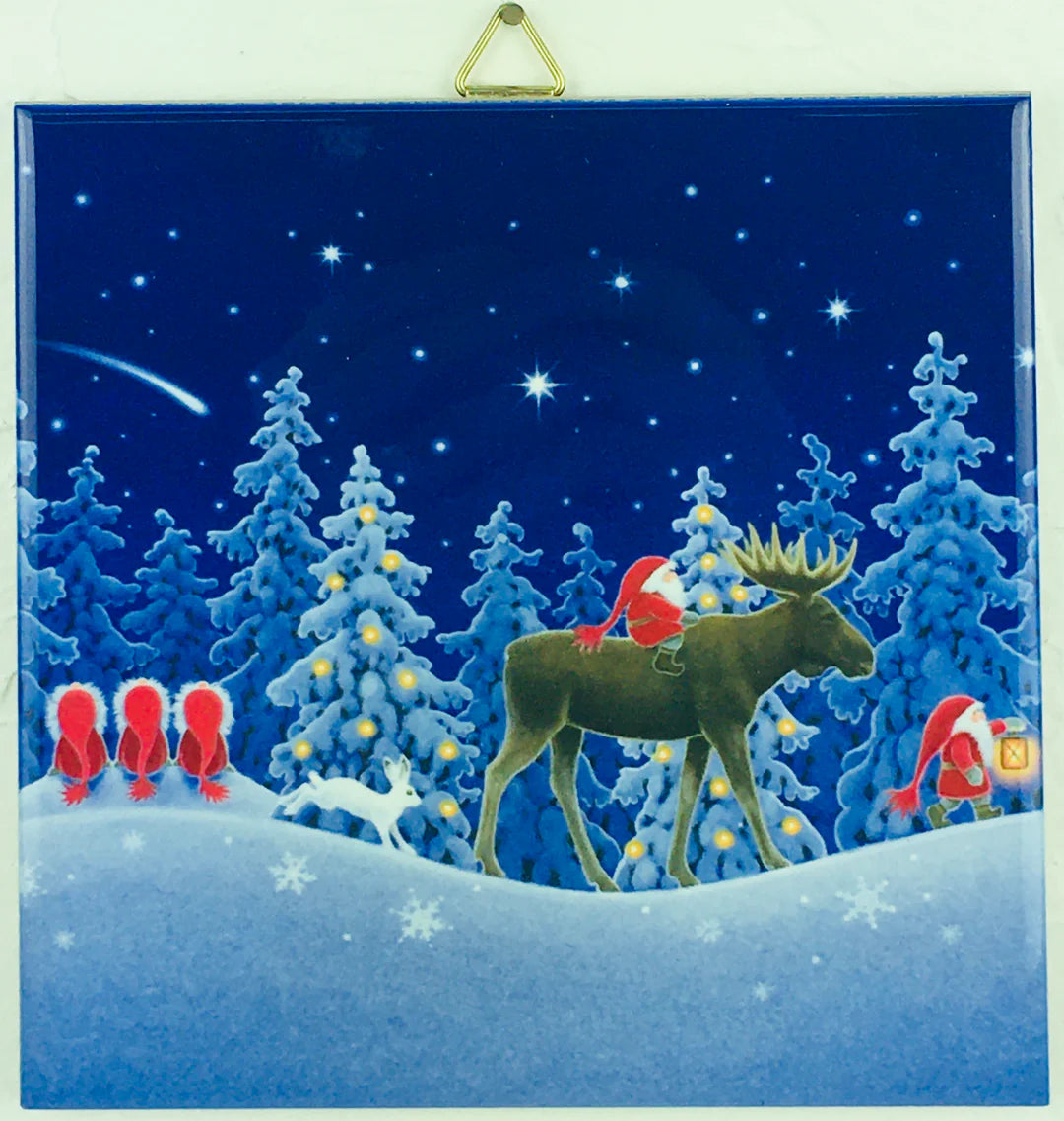 The 6" ceramic tile “Tomte Traveling on a Nordic Night” by Eva Melhuish depicts Santa riding a moose through snowy trees, gnomes, a white fox, and a shooting star—Swedish folklore brought to life for festive decor.